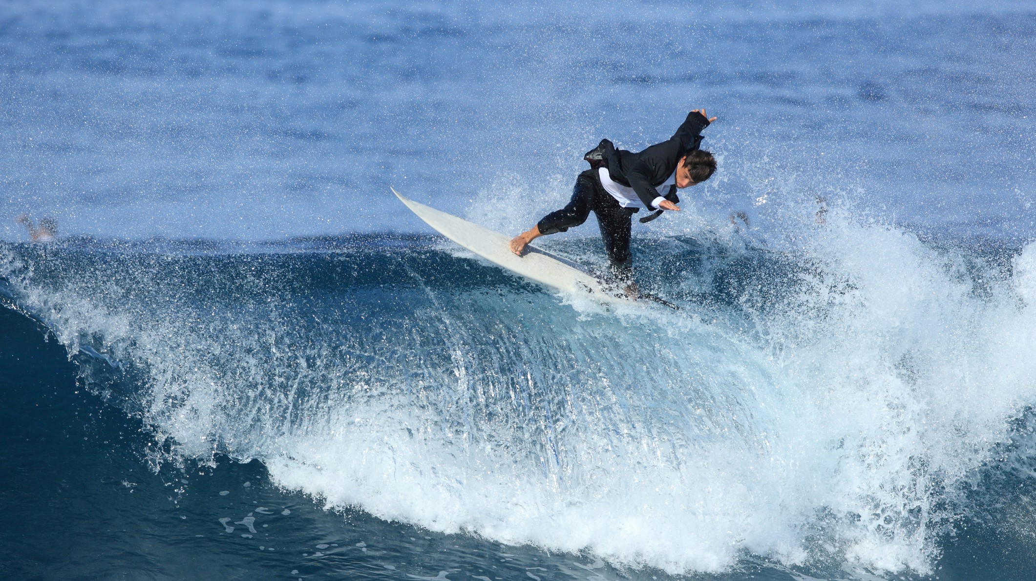 Surfer in maatpak op wilde zee