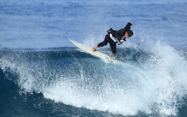 Surfer in maatpak op wilde zee