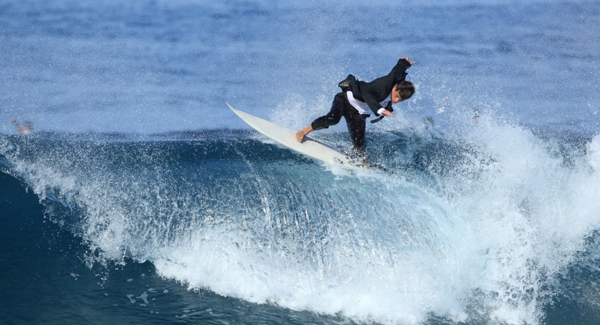 Surfer in maatpak op wilde zee