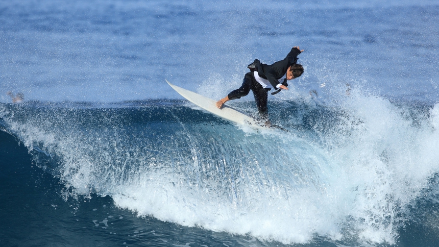 Surfer in maatpak op wilde zee