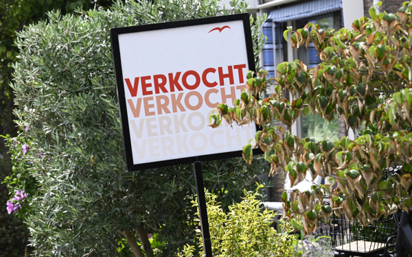 Een ‘verkocht’ bordje dat voor een huis staat