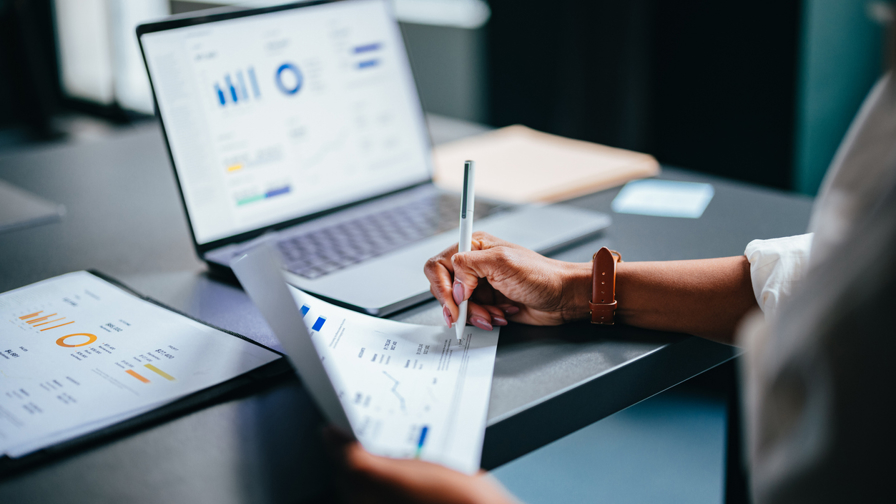 Close up van een vrouw die een rapportage uitschrijft.