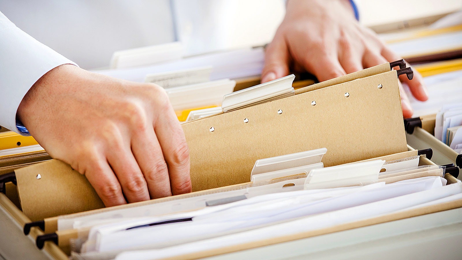 Handen bladeren door mappen