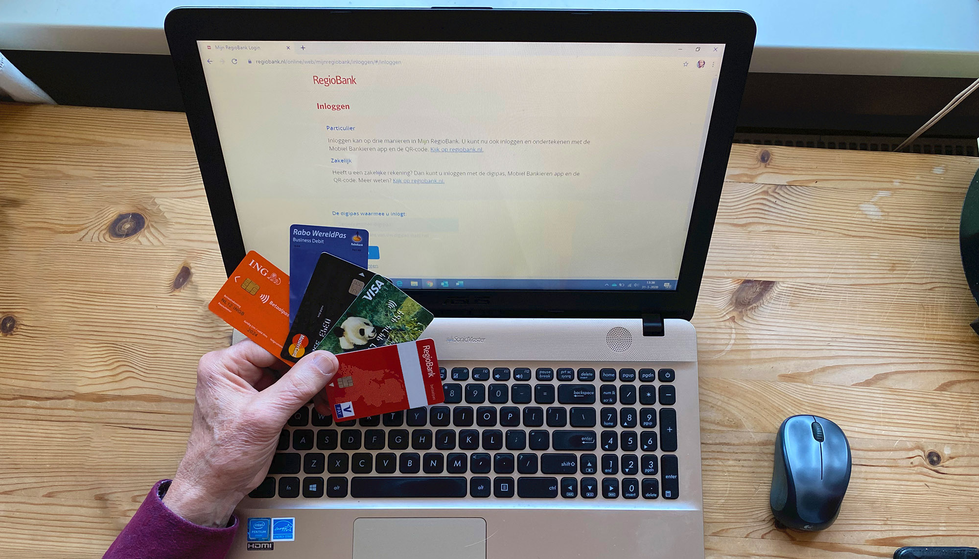 Laptop met een hand die pinpassen vasthoudt er voor