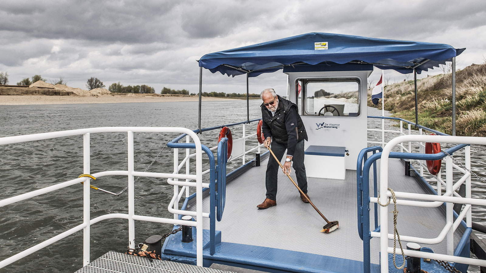 Man maakt het dek schoon van zijn veerpontje