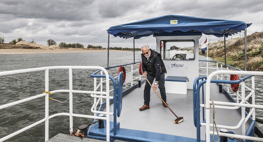 Man maakt het dek schoon van zijn veerpontje