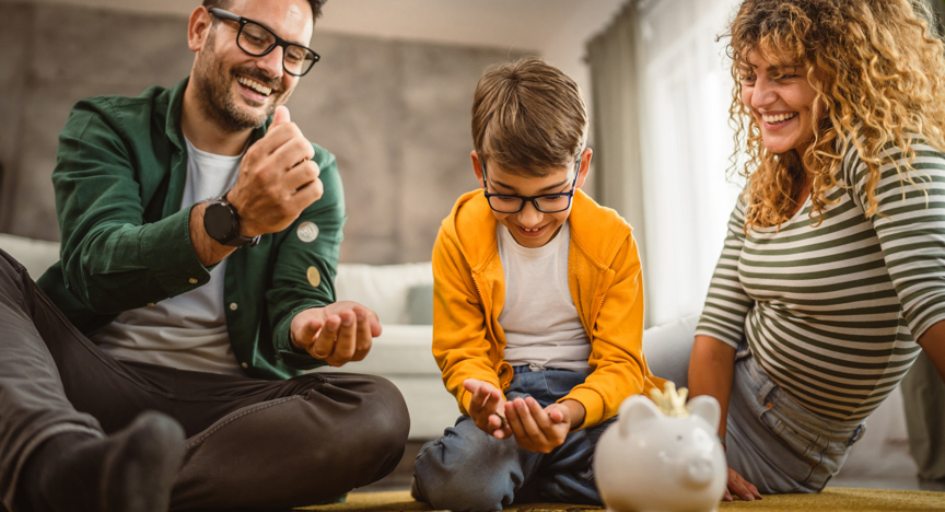 Moeder, vader en zoon zitten op het tapijt en sparen geld in de spaarpot.