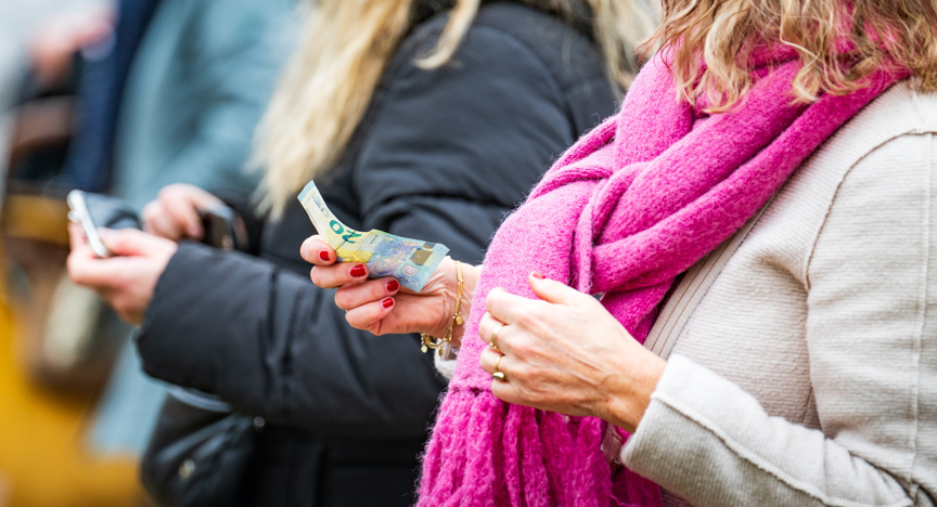 Een vrouw rekent af met een twintig euro biljet op de Bloemetjesmarkt in Groningen.