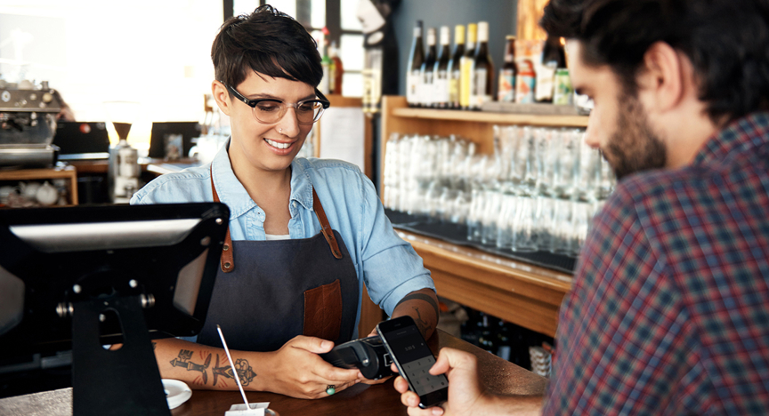 Man betaalt de rekening in het café met zijn mobiel.