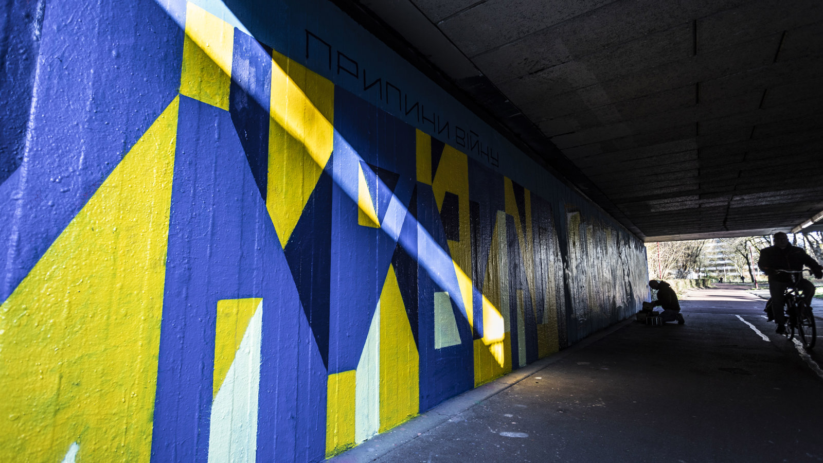 Straatkunst (legale graffiti muur) met de kleuren blauw en geel om aandacht te vragen voor de oorlog in Oekraïne