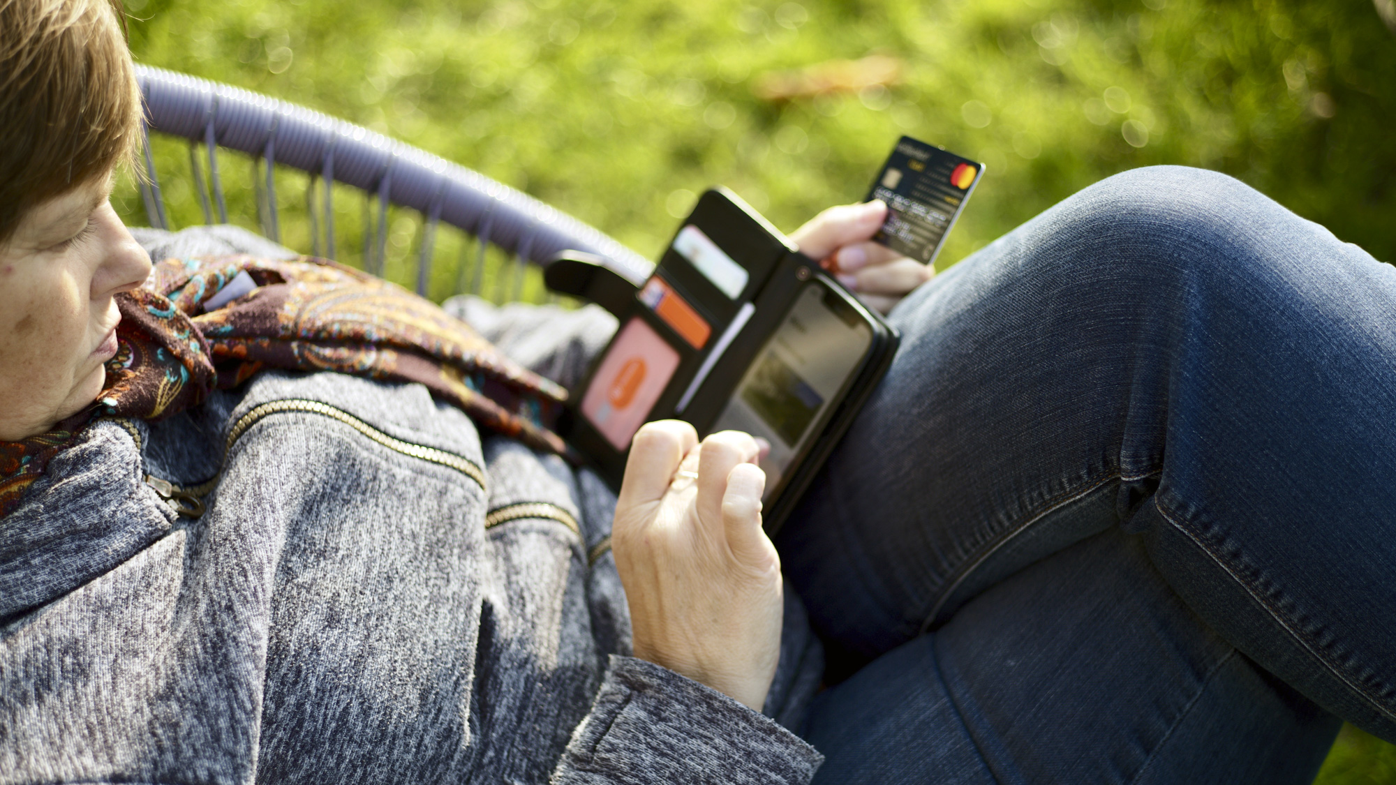 Vrouw doet een aankoop online met haar mobiele telefoon en een creditcard.