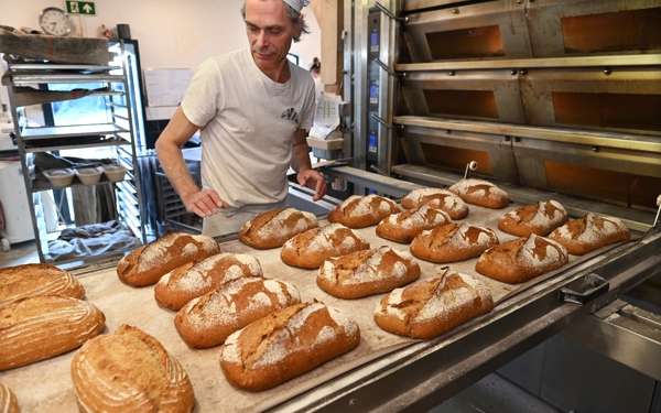 Een bakker in zijn bakkerij aan het werk.