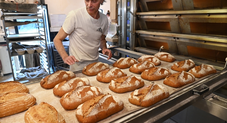 Een bakker in zijn bakkerij aan het werk.