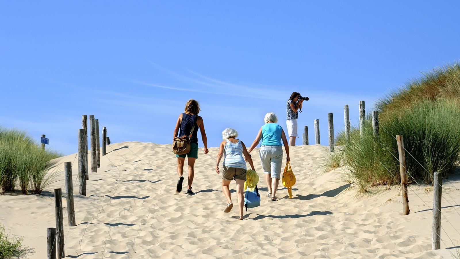 Mensen lopen het strand op - Dekkingsgraad pensioenfondsen