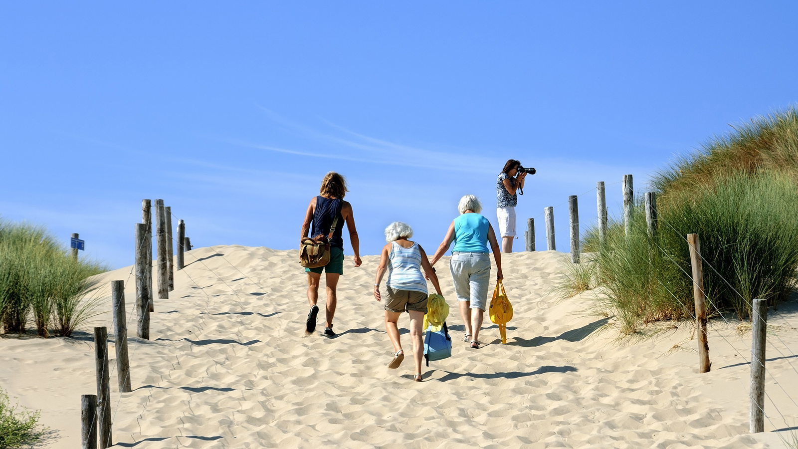Mensen lopen het strand op een heuvel op