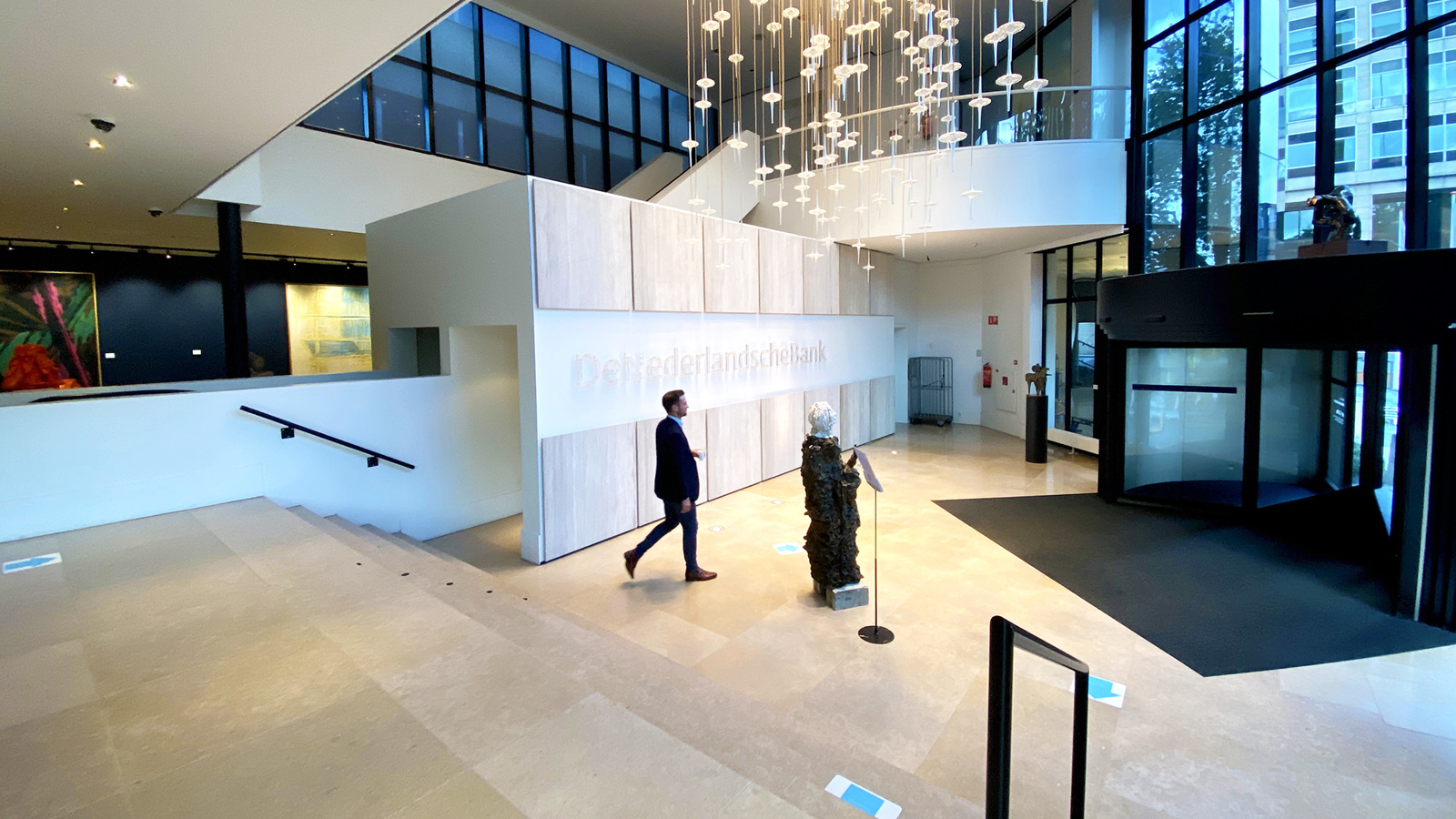 Een man loopt langs de entree binnen van het Toorop-gebouw
