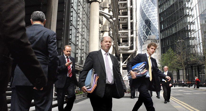 Zakenlieden lopen met stapels dossiers onder de arm door zakelijkdistrict