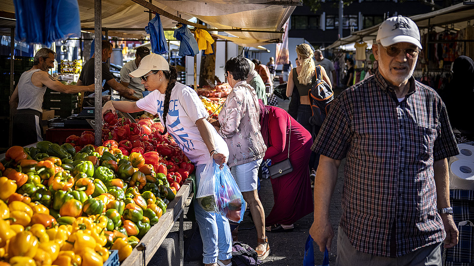 Mensen op de markt bij de groenteboer