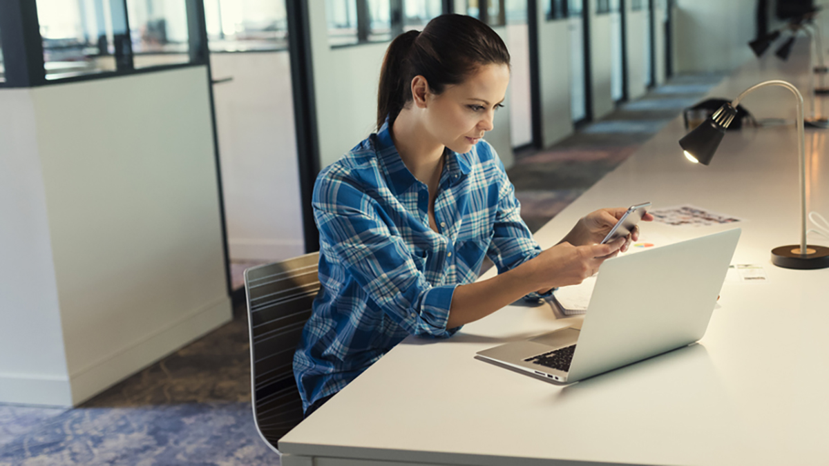 Vrouw op kantoor met computer en telefoon