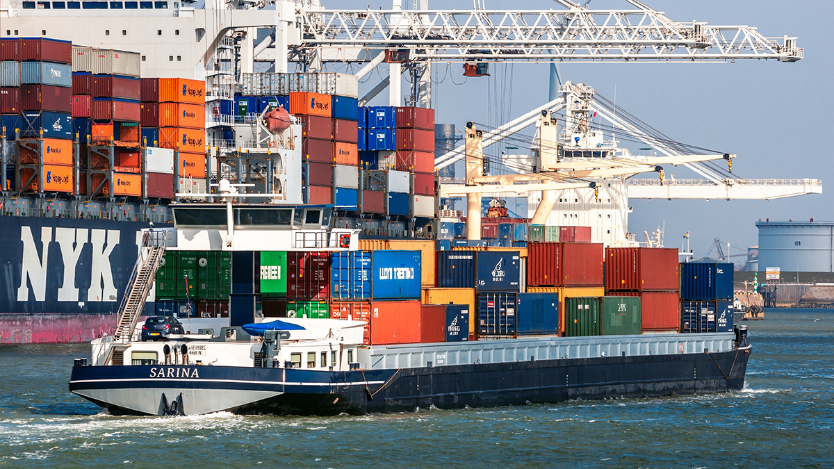Vrachtschip vaart voor haven met containers