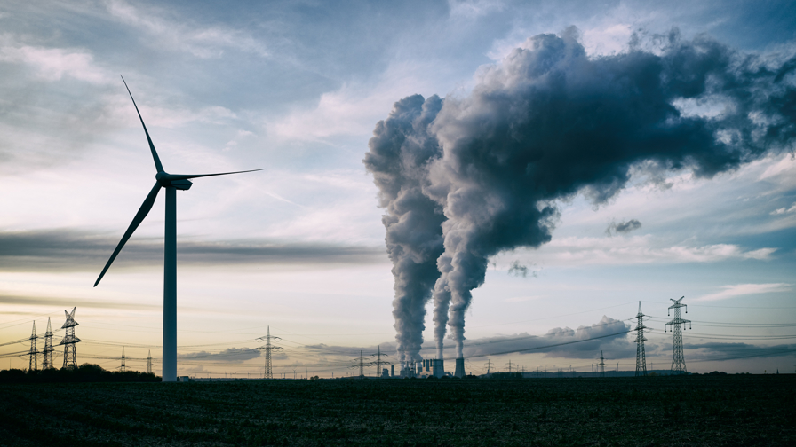 Wind energie versus steenkool gestookte elektriciteitscentrale naast elkaar.