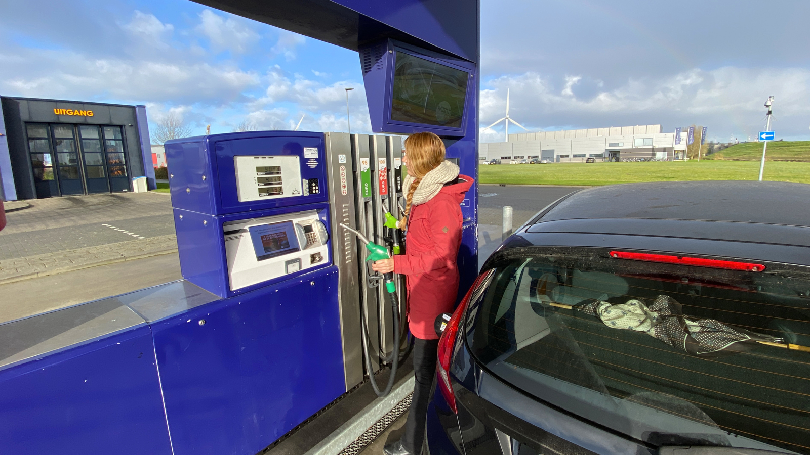 Vrouw aan het tanken bij benzinestation