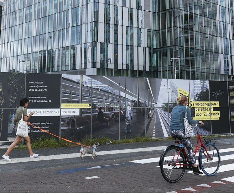 Vrouw langs de Zuidas op de fiets