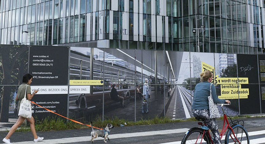 Vrouw langs de Zuidas op de fiets