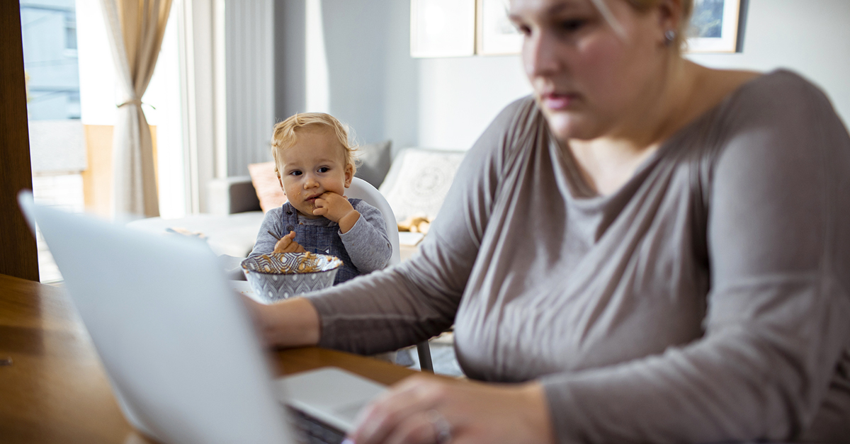Vrouw met peuter kijkt op laptop