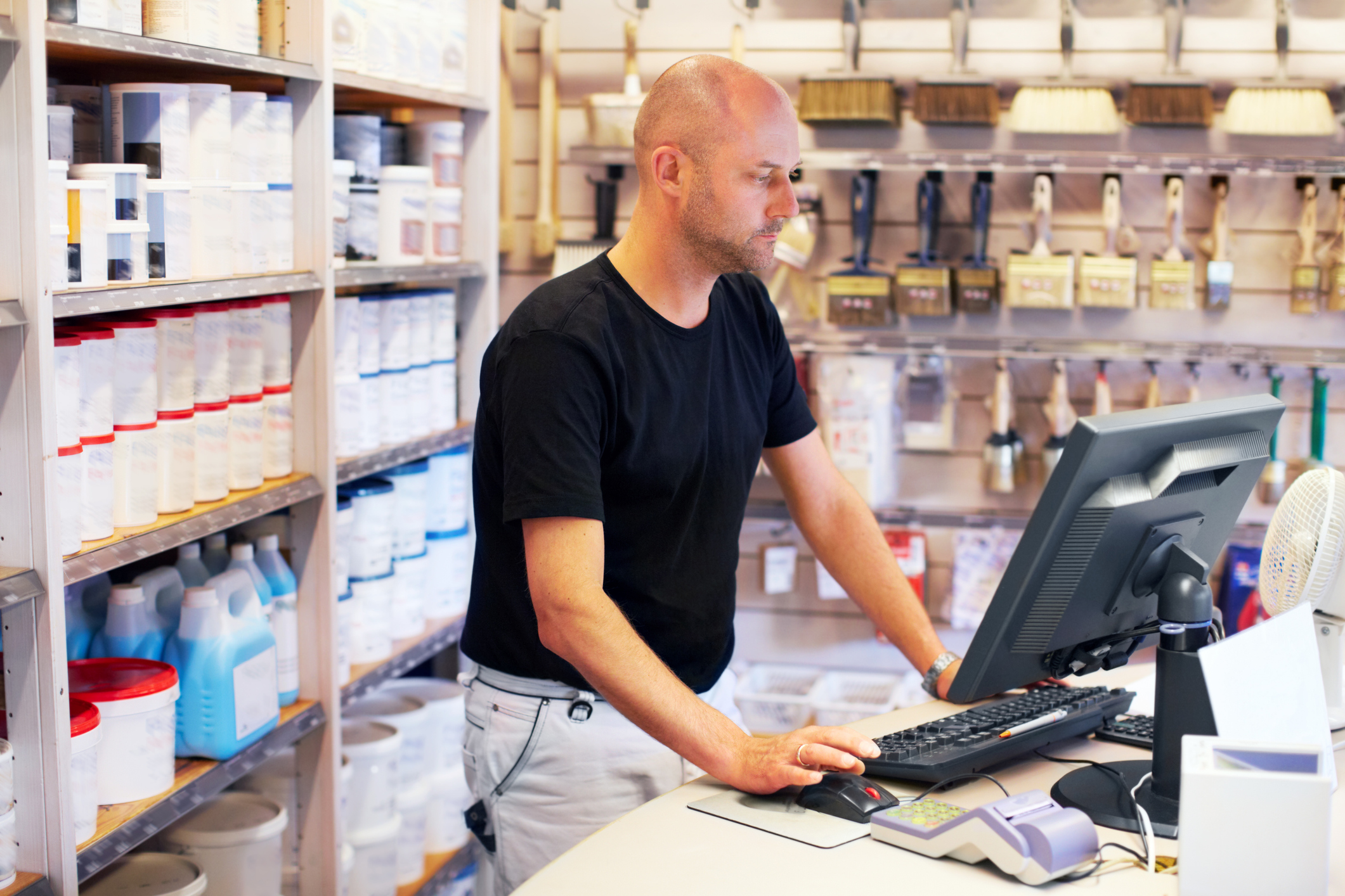 Medewerker van een doe-het-zelf winkel staat achter de kassa.