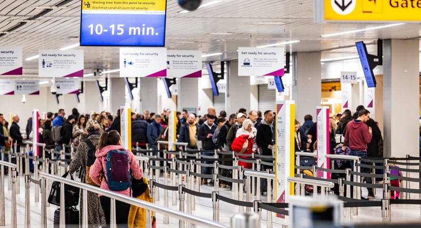Passagiers in de rij bij Schiphol