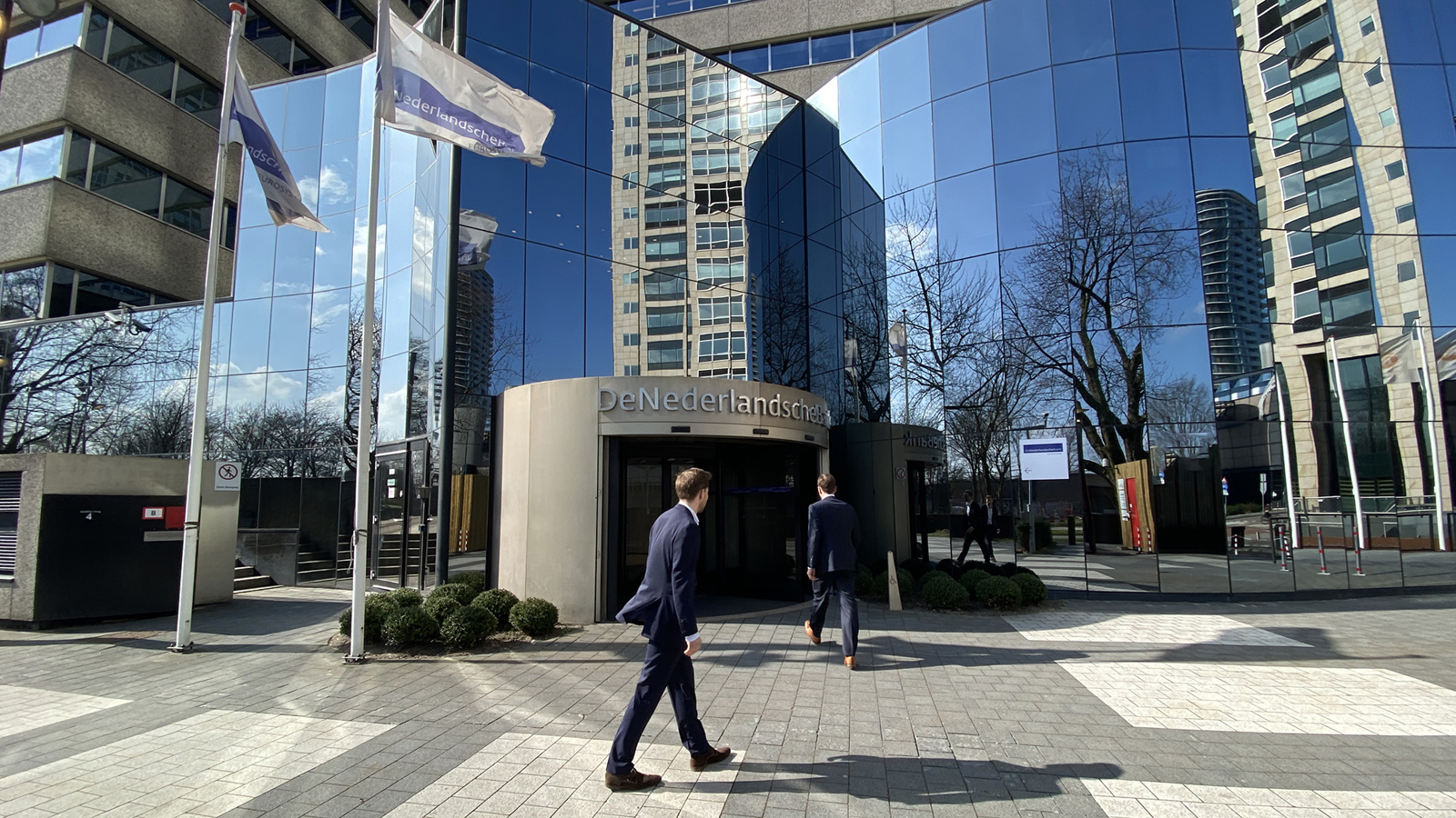 Een man loopt langs de buitenentree van het Toorop-gebouw