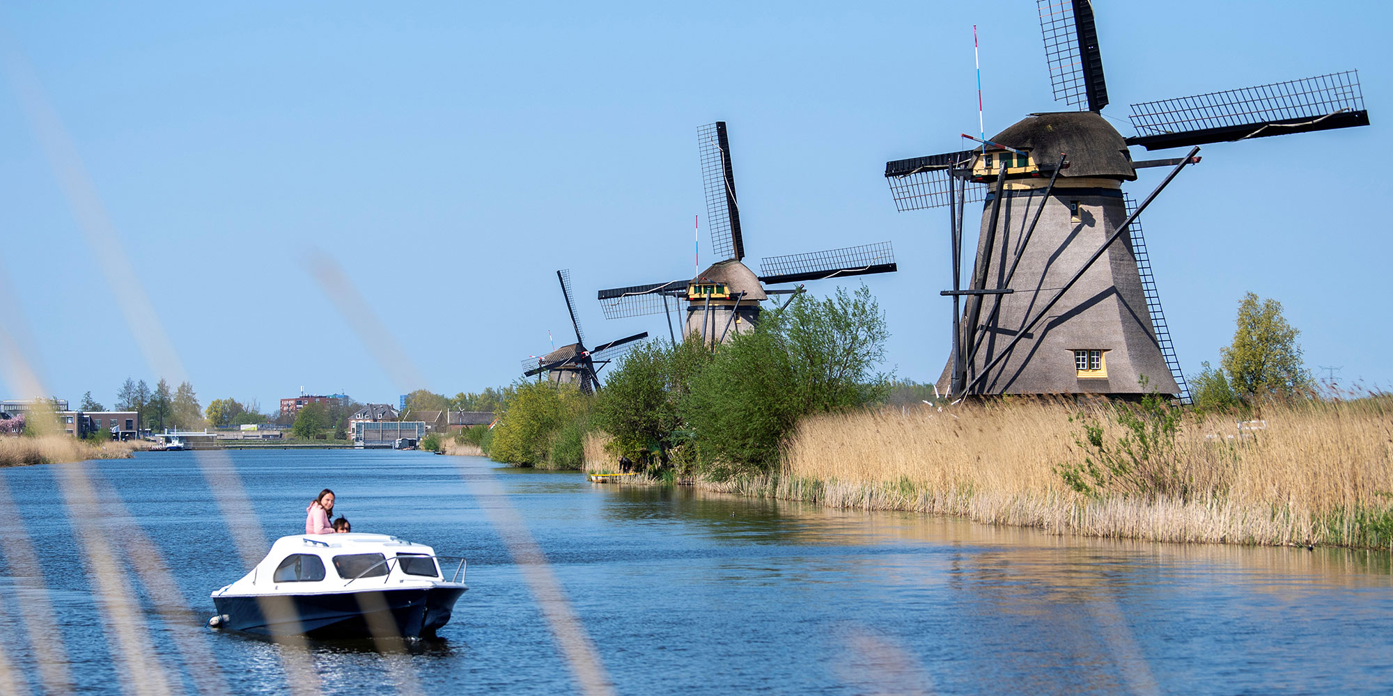 Molens aan het water waar ook een bootje vaart