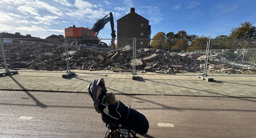 Kinderwagen bij bouwplaats huizen met hijskraan