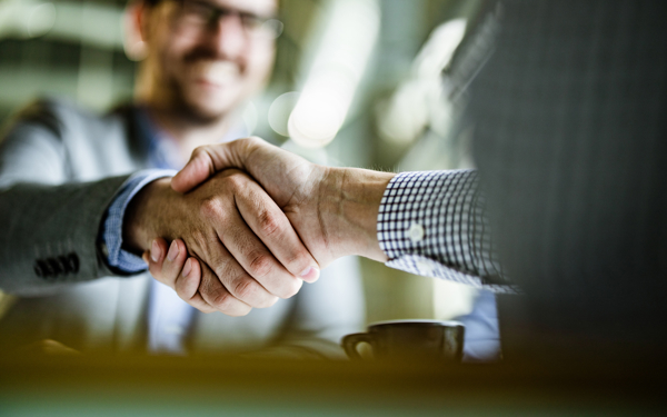 Twee personen schudden elkaar de hand.