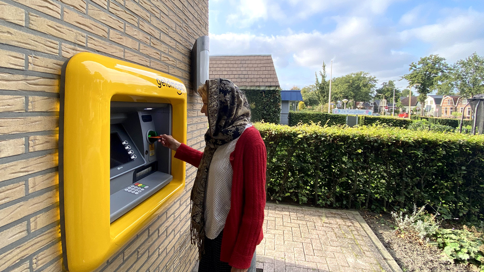 Persoon die geld pint bij een geldmaat