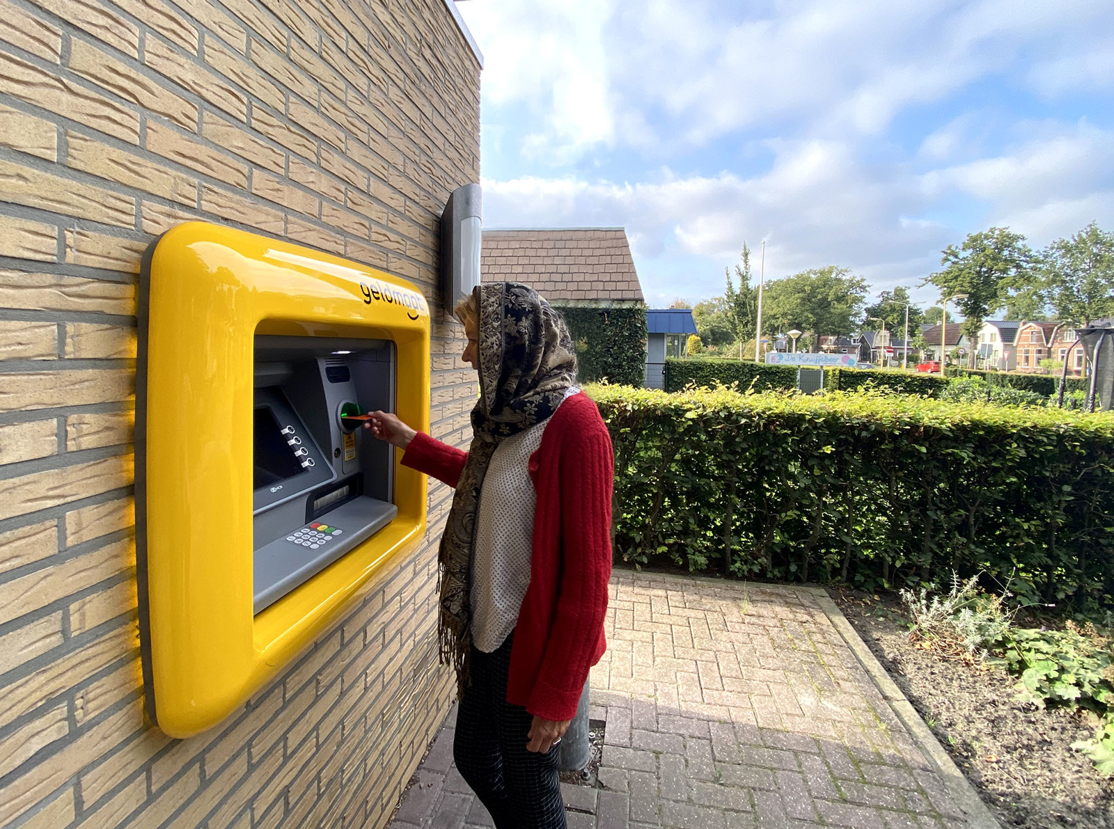 Persoon die geld pint bij een geldmaat