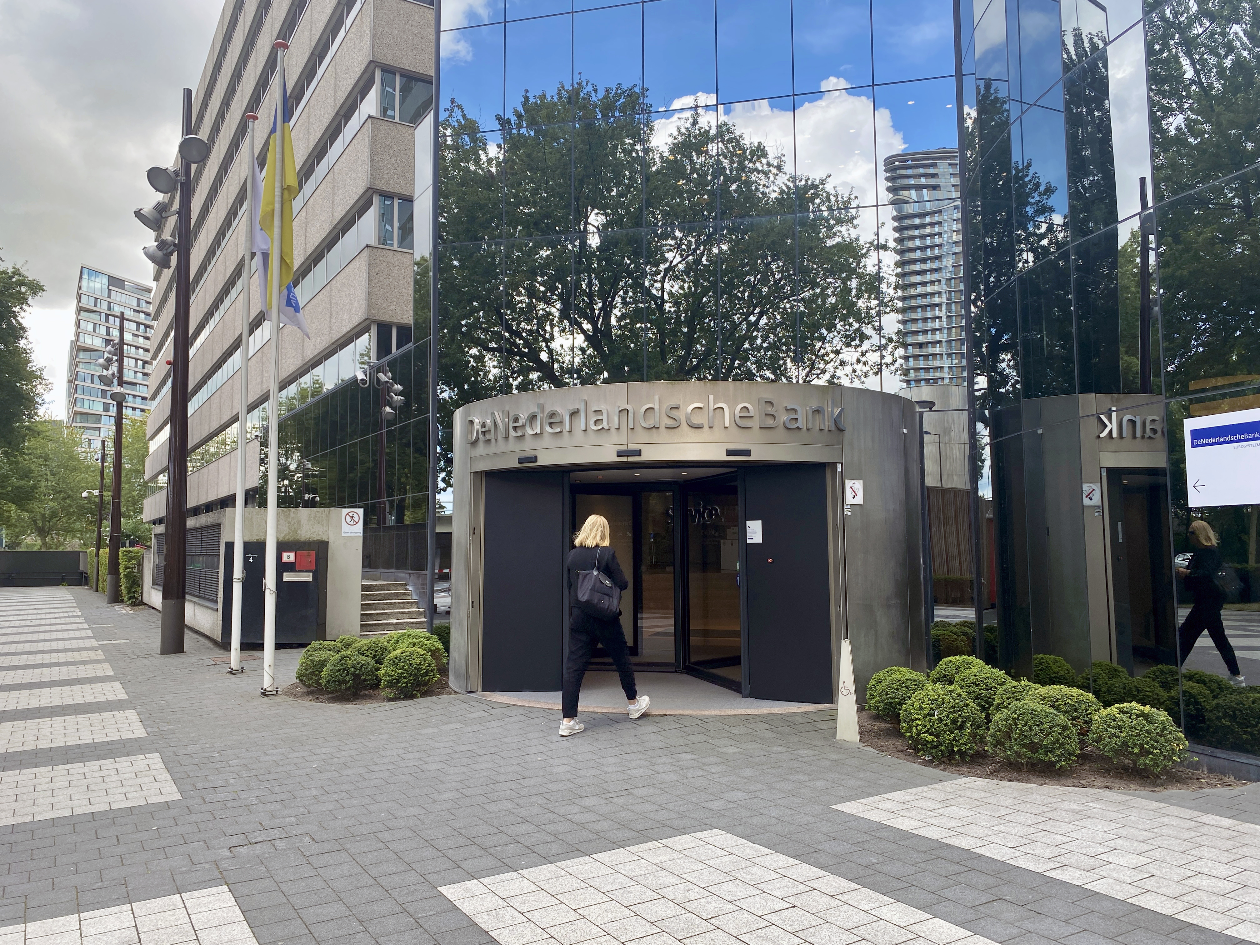 Vrouw loopt binnen bij De Nederlandsche Bank.