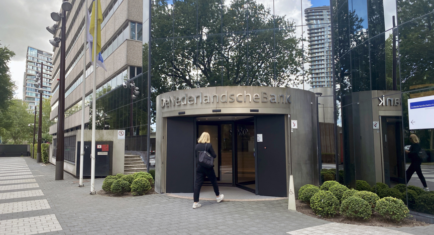 Vrouw loopt binnen bij De Nederlandsche Bank.