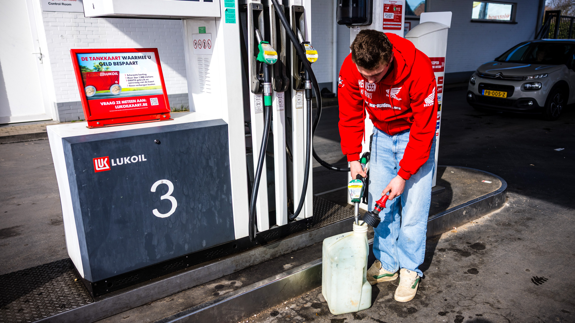 Nederlandse automobilist vult jerrycan bij een tankstation net over de Belgische grens. 