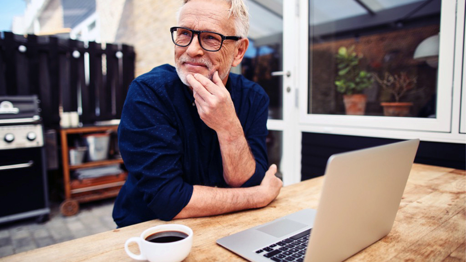 Man achter laptop met kop koffie