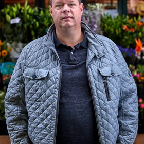man voor bloemenkar
