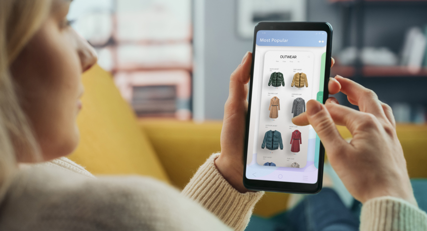 Vrouw scrolt door telefoon om een online kleding aankoop te doen