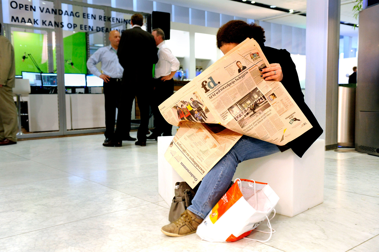 Zittend persoon krant aan het lezen