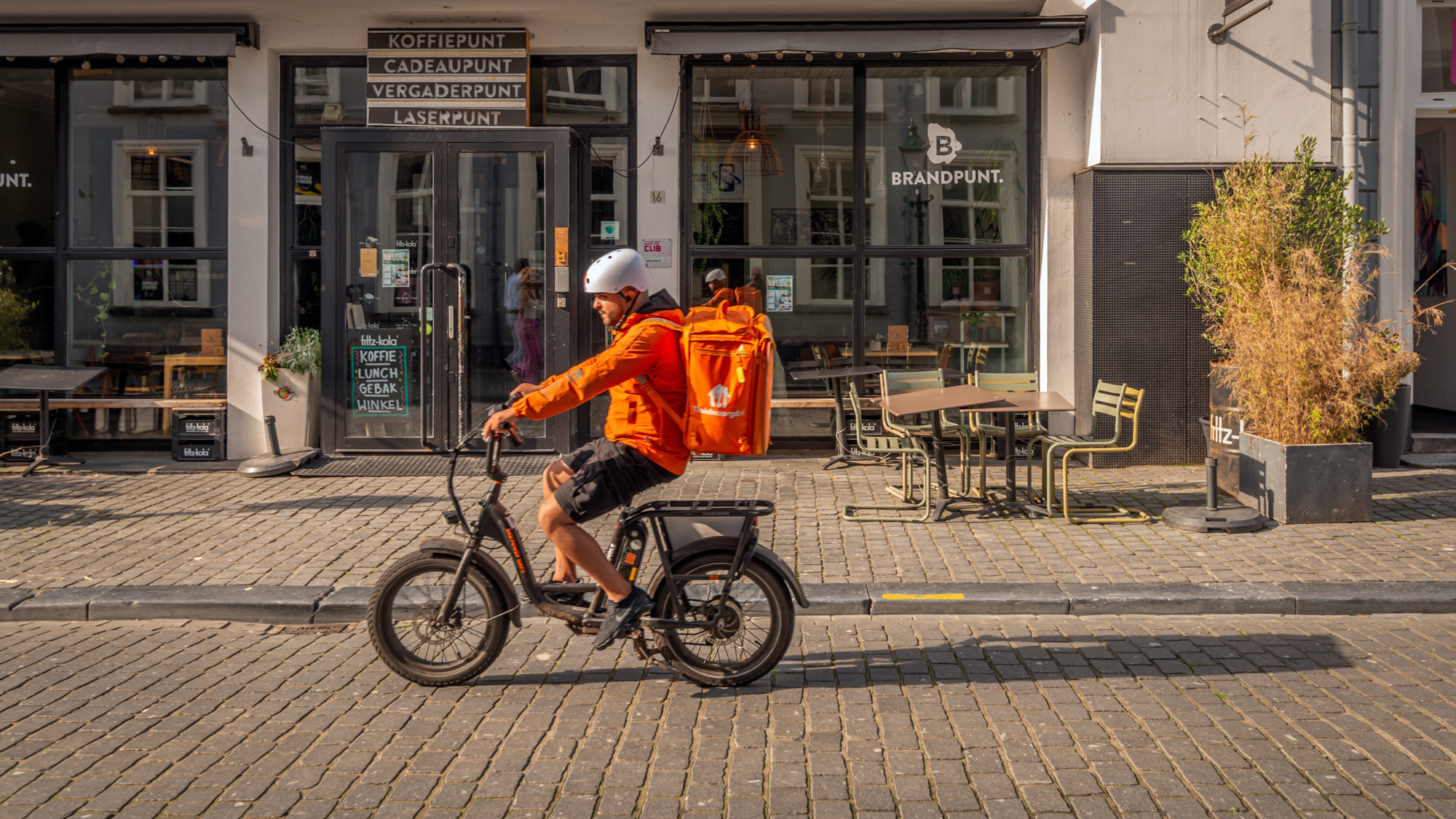 Maaltijdbezorger rijdt snel voorbij op fatbike, Breda