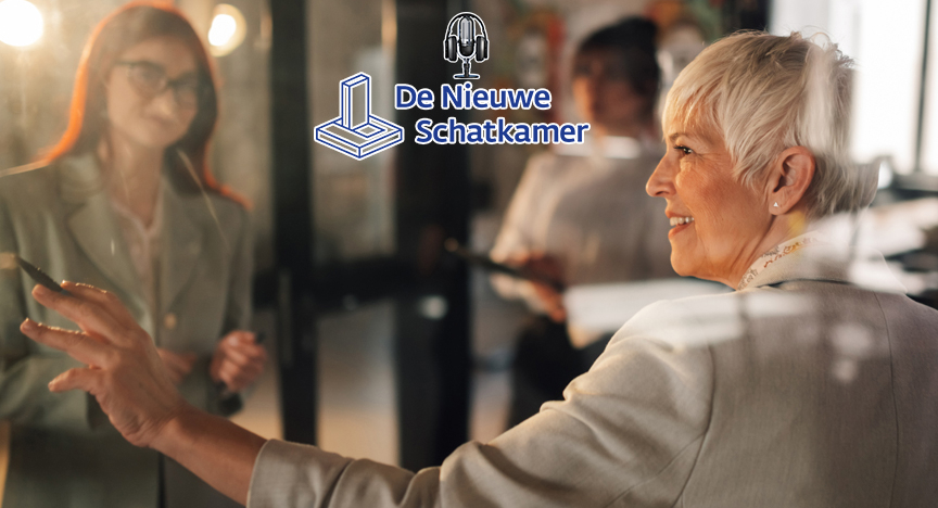 Een oudere persoon geeft uitleg en schrijft op een glazen bord, terwijl een jongere persoon aandachtig meekijkt