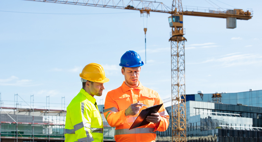 Twee bouwwerkers die iets bespreken