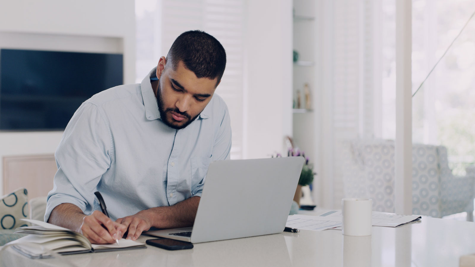 Man werkt vanuit huis op zijn laptop aan zijn aantekeningen en planning