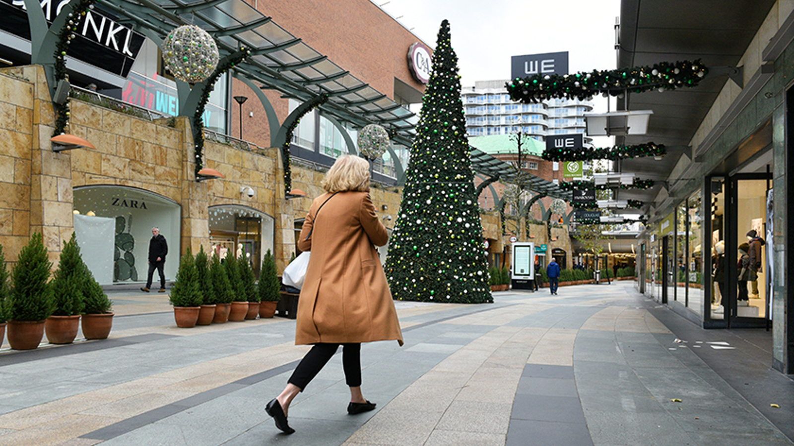 Een vrouw die wandelt in een winkelcentrum rond de kerst