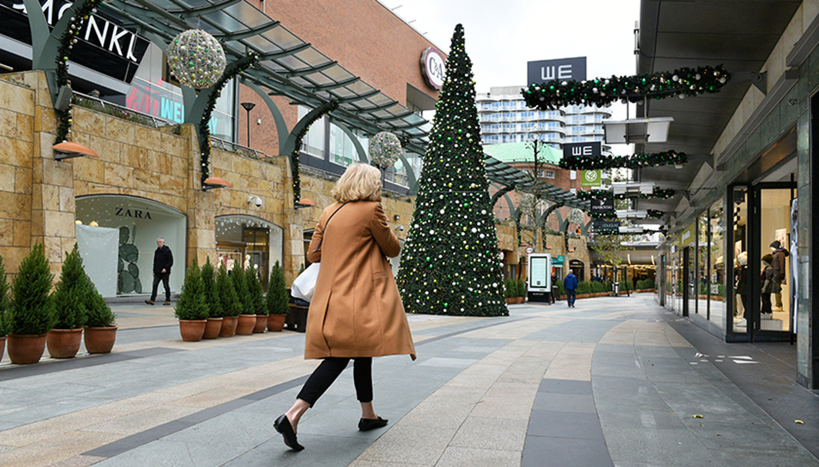 Een vrouw die wandelt in een winkelcentrum rond de kerst